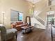 Cozy living room features soaring ceilings, hardwood floors, and large windows for natural light at 18554 E Vassar Dr, Aurora, CO 80013