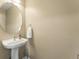 A powder room with a pedestal sink, oval mirror, and light neutral paint at 18554 E Vassar Dr, Aurora, CO 80013