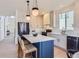 Bright, open kitchen with stainless steel appliances, island with seating and modern pendant lighting at 3466 Craftsbury Dr, Highlands Ranch, CO 80126