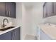 Convenient laundry room with shaker cabinets, modern faucet, and washer/dryer at 3466 Craftsbury Dr, Highlands Ranch, CO 80126