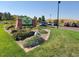 Red Tail Park entrance featuring a brick sign, landscaped flowerbeds, and visitor parking at 3466 Craftsbury Dr, Highlands Ranch, CO 80126