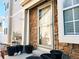 Front entrance shows brick and siding with an inviting door, potted plants add charm at 1120 S Waco St # A, Aurora, CO 80017