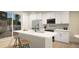 Stylish kitchen with stainless appliances, island seating, and light-filled sliding glass doors at 46517 Sunflower Ln, Bennett, CO 80102