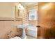 Classic bathroom with pedestal sink, tiled walls, and a window providing ample natural light at 963 N Logan St # 2, Denver, CO 80203