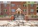 Detailed view of the brick building's entrance, with a gated courtyard and classic architectural details at 963 N Logan St # 2, Denver, CO 80203