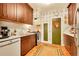 Well-lit kitchen with vintage wallpaper, wood cabinets, and a cozy rug on the parquet floor at 963 N Logan St # 2, Denver, CO 80203