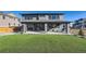 A backyard showcasing a well-manicured artificial turf lawn, covered patio, and well-maintained landscaping at 14209 Beebalm Loop, Parker, CO 80134