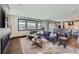Open-concept living room with a fireplace, large windows, and seamless access to the dining area at 14209 Beebalm Loop, Parker, CO 80134