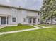 Exterior of the townhomes featuring well-maintained lawns and muted light gray siding at 1932 S Oswego Way, Aurora, CO 80014