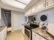 Bright kitchen features stone counters, white cabinets, stainless steel oven, and access to dining room at 1932 S Oswego Way, Aurora, CO 80014