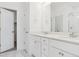Bright bathroom featuring double vanity, white cabinets, and a large mirror at 6902 Huddersfield Ln, Castle Pines, CO 80108