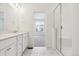All white bathroom with double vanity and step-in shower with glass enclosure at 6902 Huddersfield Ln, Castle Pines, CO 80108