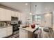 Modern kitchen featuring stainless steel appliances, a kitchen island with seating, and stylish pendant lighting at 6902 Huddersfield Ln, Castle Pines, CO 80108