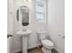 Well-lit bathroom with a pedestal sink, modern fixtures, and a separate toilet area at 1368 Penner Dr, Erie, CO 80026