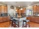 Stylish kitchen featuring a center island with seating, granite countertops, wood cabinets, and ample natural light at 3727 Starry Night Loop, Castle Rock, CO 80109