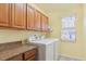 Bright laundry room with wood cabinets, laminate countertop, washer, and dryer at 3727 Starry Night Loop, Castle Rock, CO 80109