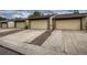 Rear view of townhouses showcasing attached garages and parking at 6594 W Mississippi Way, Lakewood, CO 80232