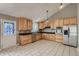 View of kitchen with wood cabinets, stainless steel appliances, and tile floor at 6594 W Mississippi Way, Lakewood, CO 80232