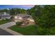Aerial view of a charming two-story home showcasing lush landscaping and a brick-lined driveway and entryway at 10694 E Dorado Ave, Englewood, CO 80111