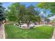 Lush backyard featuring a stone patio with outdoor seating and mature trees offering shade at 10694 E Dorado Ave, Englewood, CO 80111