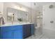 Bathroom showcasing blue cabinetry, double sinks and glass shower doors at 10694 E Dorado Ave, Englewood, CO 80111