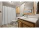 Bright bathroom with a wood-framed mirror, vanity, and a shower with a white curtain at 10694 E Dorado Ave, Englewood, CO 80111