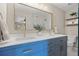 Beautiful bathroom featuring blue cabinetry, double sinks and a wide mirror at 10694 E Dorado Ave, Englewood, CO 80111