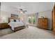 Bright bedroom features a ceiling fan and a wooded headboard bed frame at 10694 E Dorado Ave, Englewood, CO 80111