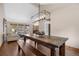 View of the dining room with wood table and bench, contemporary chandelier, and open layout to the living room at 10694 E Dorado Ave, Englewood, CO 80111
