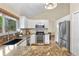 Modern kitchen with stainless steel appliances, granite counters, white cabinets, and view into the dining area at 10694 E Dorado Ave, Englewood, CO 80111