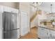 Kitchen featuring stainless steel refrigerator, granite counters, pantry and open staircase to the upper level at 10694 E Dorado Ave, Englewood, CO 80111