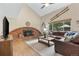 Cozy living room with a brick fireplace, vaulted ceiling, leather sectional, and large windows for natural light at 10694 E Dorado Ave, Englewood, CO 80111