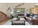 Comfortable living room with leather sectional, brick accent wall, and view of the well-maintained backyard at 10694 E Dorado Ave, Englewood, CO 80111