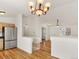 Open-concept living space with hardwood floors connecting the kitchen and dining areas at 5280 E 128Th Way, Thornton, CO 80241