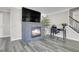 Cozy living room with fireplace, TV, desk, and grey wood flooring at 9593 Racoon Pl, Littleton, CO 80125