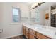 Bathroom featuring double vanity, updated lighting, wood-look floors and a shower with decorative tile accents at 10535 Holyoke Dr, Parker, CO 80134