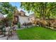 Well-manicured lawn with patio, garden, and seating, framed by mature trees and privacy fencing at 3016 N Franklin St, Denver, CO 80205