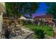Evening backyard featuring a patio with garden, lounge chairs, brick building, and lush landscaping at 3016 N Franklin St, Denver, CO 80205