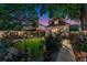 Backyard at twilight with lush gardens, mature trees, and a well-manicured lawn at 3016 N Franklin St, Denver, CO 80205