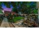 Twilight backyard with well-manicured lawn, decorative accents, patio area, and lush landscaping at 3016 N Franklin St, Denver, CO 80205
