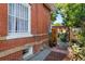 Brick home exterior featuring a landscaped side yard with stone pathway and green accents at 3016 N Franklin St, Denver, CO 80205