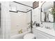Tiled bathroom featuring a shower-tub combo, white vanity, black accents, and decorative plants at 3016 N Franklin St, Denver, CO 80205