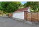 Detached one car garage with red brick and a solid white garage door next to a fenced in yard at 3016 N Franklin St, Denver, CO 80205