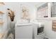 Well-lit laundry room with modern washer and dryer units and decoratively painted brick walls at 3016 N Franklin St, Denver, CO 80205