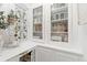 White pantry cabinet with glass doors showcases charming farmhouse-style decorations and natural light at 3016 N Franklin St, Denver, CO 80205