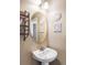 Chic powder room with an oval mirror, wall decor, and a pedestal sink, perfect for guests at 1280 Galactic Pl, Castle Rock, CO 80108