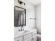 Stylish bathroom showcasing a white vanity with marble countertop, black fixtures, and a framed mirror at 1280 Galactic Pl, Castle Rock, CO 80108