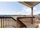 Wood deck overlooks backyard with a beautiful view of houses beyond a large grassy field on a sunny day at 1280 Galactic Pl, Castle Rock, CO 80108