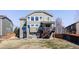 Backyard view of a two-story house with a deck and patio, surrounded by a grassy lawn and a wood fence at 1280 Galactic Pl, Castle Rock, CO 80108