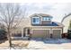 Two-story home with a three-car garage, brick accents, and neutral siding at 1280 Galactic Pl, Castle Rock, CO 80108